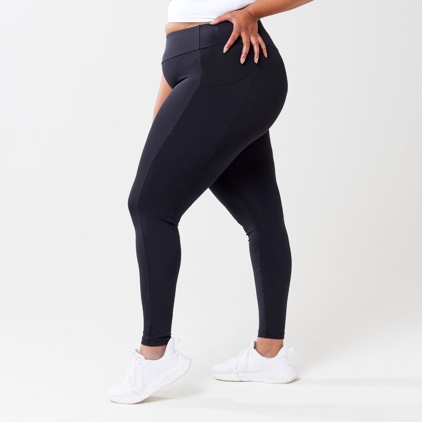 Plus model wearing black leggings for use in active lifestyles as well as casual living.