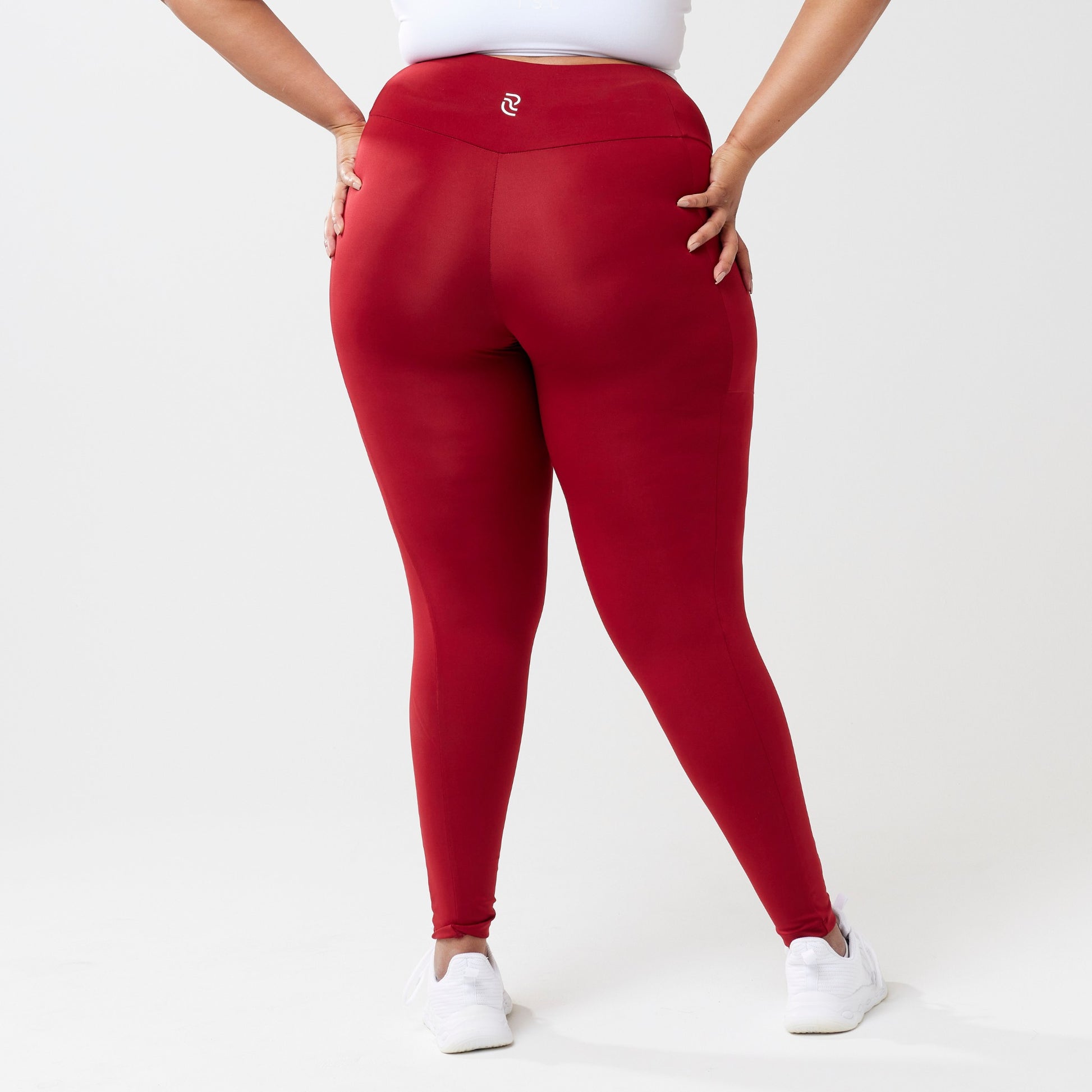 Plus model wearing red leggings for use in active lifestyles as well as casual living.